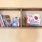 Shelf with books, puzzles and a "Good friends, good wine, good times sign.